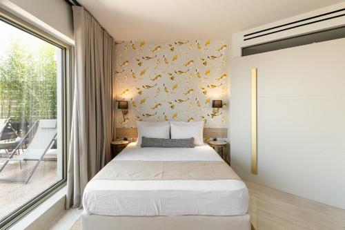 a bedroom with a bed and a large window at #FLH -The Koi Apartment, Thessaloniki in Thessaloniki