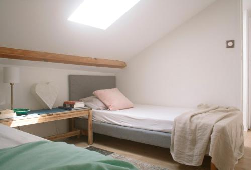 um quarto com uma cama e uma mesa com uma almofada em Maison calme - Frontière Montagne et Plage em Urrugne