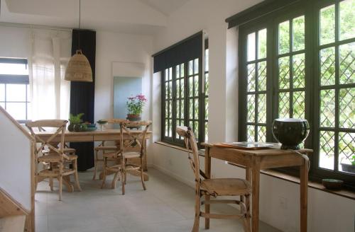 a kitchen with a table and chairs and windows at Maison calme - Frontière Montagne et Plage in Urrugne