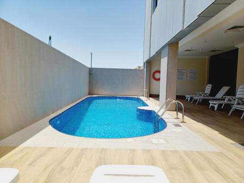 una gran piscina en un edificio con mesas y sillas en Royal Qatar Hotel, en Doha