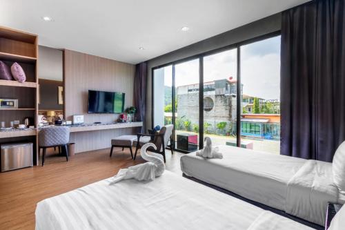 Una habitación de hotel con dos camas y una gran ventana. en New Luxury Two bedroom private swimming pool villa with complete supporting facilities, convenient for travel 800 meters to Kamala Beach H09, en Kamala Beach