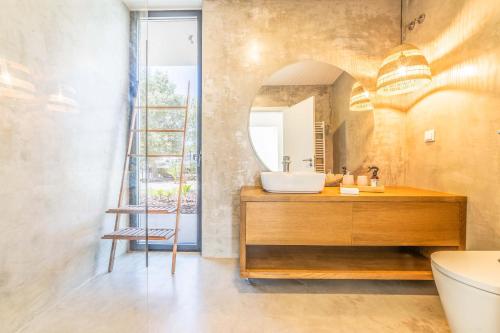 ein Bad mit einem Waschbecken und einem Spiegel in der Unterkunft Villa Arrabida in Quinta do Conde