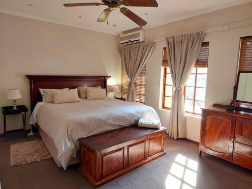 um quarto com uma cama e uma ventoinha de tecto em Khalila's Equestrian Cottage em Midrand