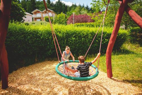 a boy and a girl playing on a swing at Marienhöh - Hideaway & Spa in Langweiler