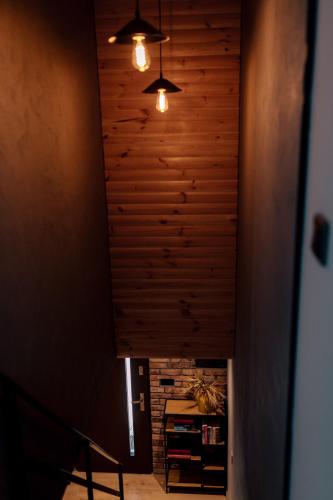 a room with a wooden ceiling with two lights at Apartamenty Koziołek in Srebrna Góra