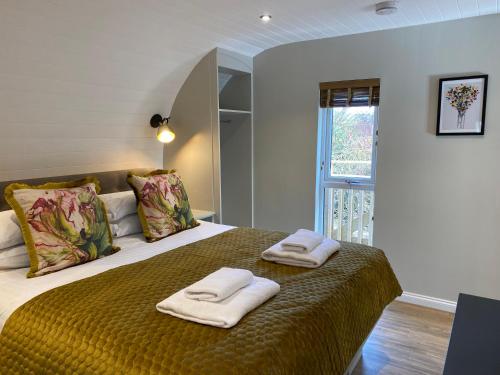 um quarto com uma cama com duas toalhas em Beechnut Lodge with Hot Tub em Cupar