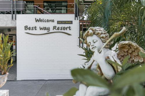 巴衝的住宿－Best Way Resort，雕像坐在最佳度假标志前