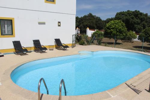 a large blue swimming pool next to a building at Tapada dos Ribeiros in Alpalhão