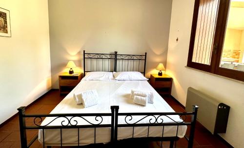 a bedroom with a large white bed with two lamps at Villa Rina in Avola