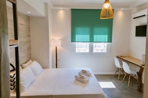 een slaapkamer met een bed met twee handdoeken erop bij Ammos Luxury Suite in Karistos