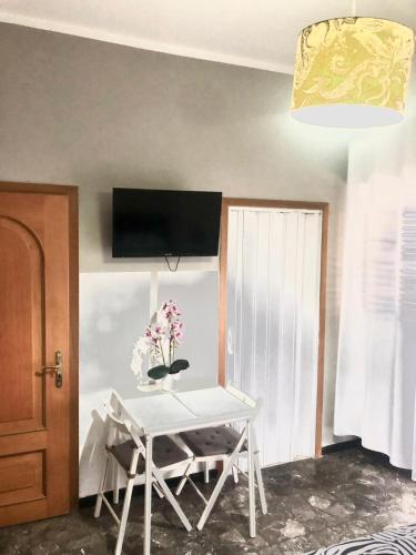 Zimmer mit einem Tisch und einem TV an der Wand in der Unterkunft CASA PICCOLA LELLA in Policoro