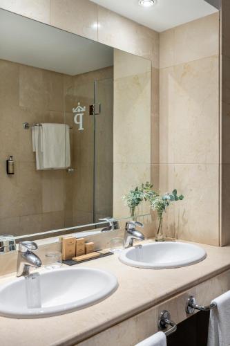 two sinks in a bathroom with a large mirror at Parador de Ronda in Ronda
