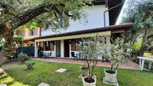 una casa con dos árboles en el patio en Elisa Holidays Apartments, en Puegnago sul Garda