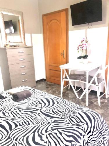 Schlafzimmer mit einem Zebra-Bett und einem Tisch in der Unterkunft CASA PICCOLA LELLA in Policoro