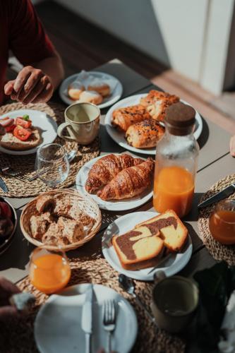 a table topped with plates of food and orange juice at Methe in Lizzano