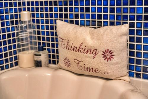 a pillow with the words stimulating time sitting on a sink at Finest Retreats - Valley View in Camelford
