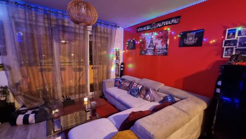 un soggiorno con divano bianco e parete rossa di Love Room Amour Glamour Lib proche gare rer 5 minute à pied ad Aulnay-sous-Bois