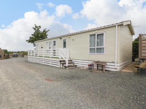a mobile home on the side of a gravel road at Gwel Eryri in Gaerwen