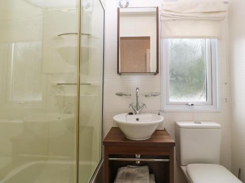 a bathroom with a sink and a toilet and a shower at Gwel Eryri in Gaerwen