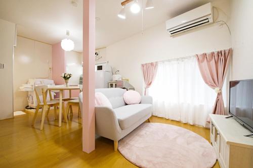a living room with a white couch and a table at Primehome Ninomiya in Fukiaichō