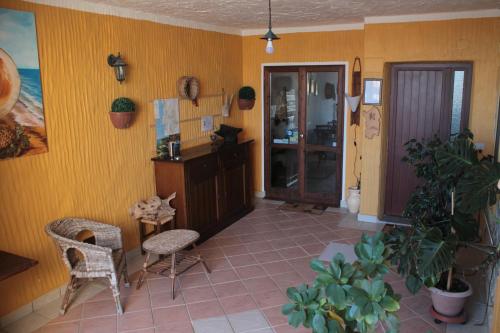 sala de estar con paredes y sillas de color amarillo y mesa en S'Alzolitta, en Magomadas