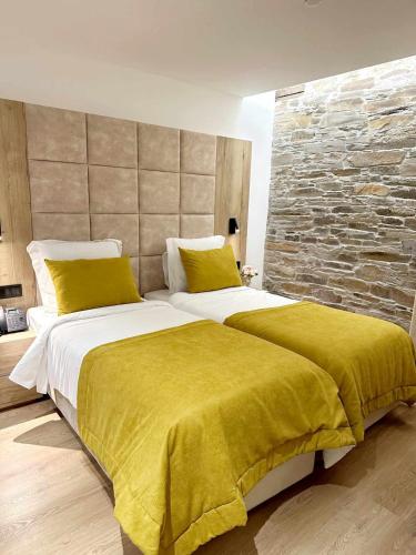 a bedroom with a large bed with a yellow blanket at Coração do Tua Hotel in Mirandela
