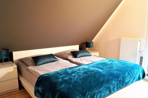 1 dormitorio con 2 camas y sábanas azules en Modernes, großzügiges Ferienhaus - Naturstrand, großer Garten, Ruhe, en Hof Barendorf