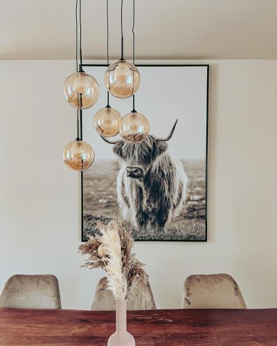 a painting of a cow hanging on a wall at Domaine du Mimosa in Perros-Guirec