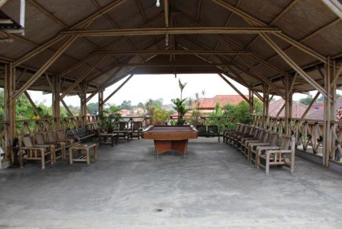 un gran pabellón con mesa de billar y sillas en Homestay at Candi Gebang by ecommerceloka, en Sleman
