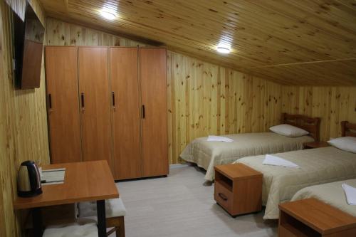 a room with two beds and a wooden wall at Hostel VinoGrad in Haysyn