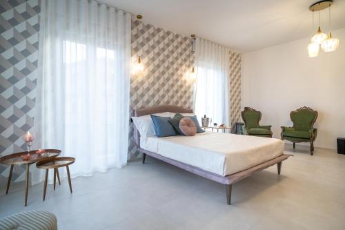 a bedroom with a bed and a table and chairs at Maiolica Rooms in Ragusa