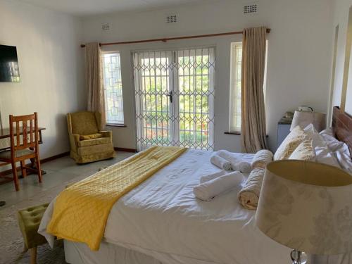 a bedroom with a large white bed with towels on it at Maisha@Toti in Amanzimtoti