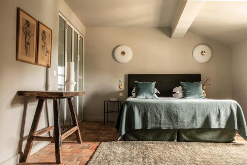 a bedroom with a bed with a green bedspread at Baumanière - Les Baux de Provence in Les Baux-de-Provence