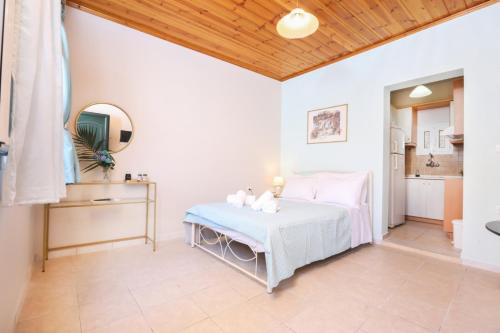a white bedroom with a bed and a bathroom at Andromache's in Gastouri