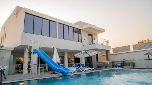 a villa with a pool and a slide at Al Qand Chalet For Families Only in Half Moon Bay