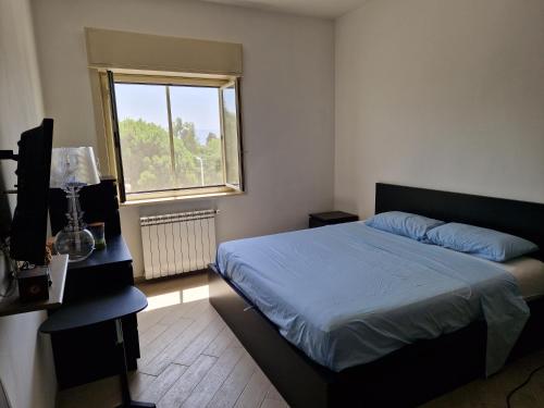 1 dormitorio con cama y ventana en La casa di Andrea, en Messina