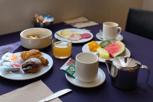 uma mesa com pratos de comida e chávenas de café em Onix Liceo em Barcelona