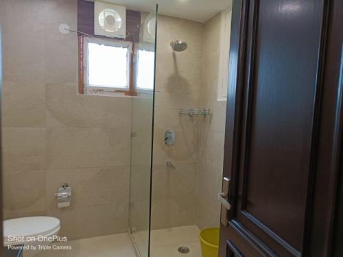a bathroom with a glass shower with a toilet at Dynamic Room(R3) Embellished with Excellence-Heart of City in New Delhi