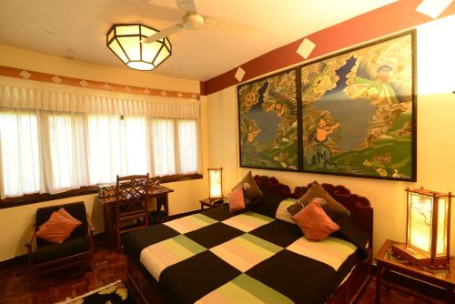 a bedroom with a bed and a large painting on the wall at Norling House in Dharamshala