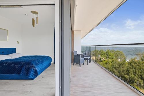 a bedroom with a bed and a balcony with a view at Solaris Darłówko Premium Emilia Strupiechowska in Darłowo
