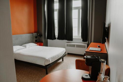 Un pat sau paturi într-o cameră la Hotel Historique et Manoir Route 66