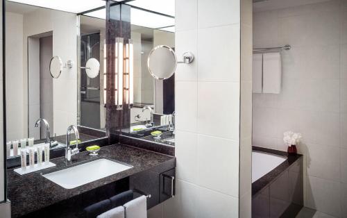 a bathroom with two sinks and a large mirror at Le Méridien Stuttgart in Stuttgart
