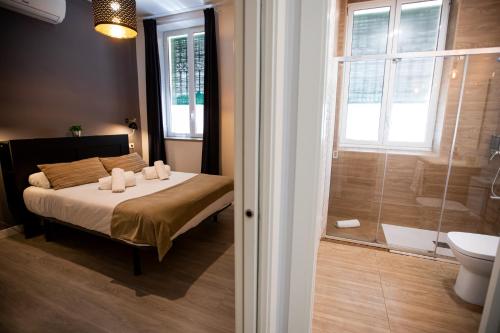 um quarto com uma cama e uma casa de banho com um chuveiro em Apartamentos Doña Concha em Sevilha