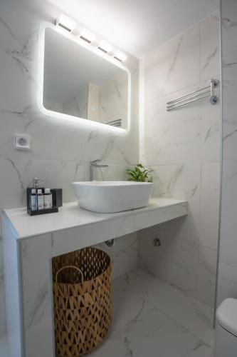 a white bathroom with a sink and a mirror at Villa Nostos in Dhragoulás