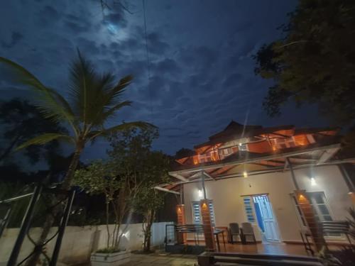 a house at night with a palm tree at Nostalgia Homestay in Vythiri
