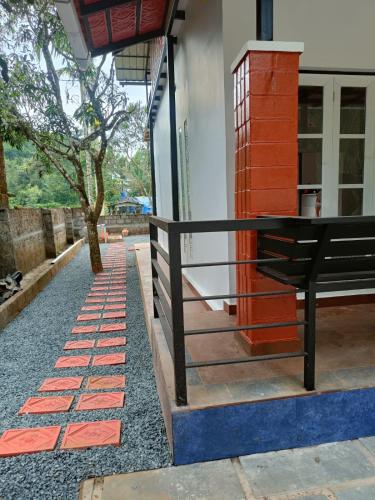 a black bench sitting outside of a house at Nostalgia Homestay in Vythiri