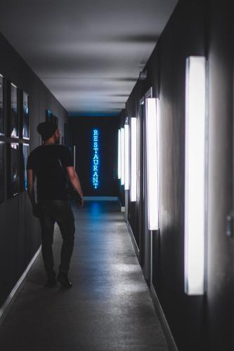 a man walking down a hallway in a dark room at Hotel Oderberger in Berlin