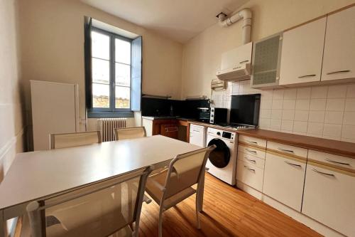 uma cozinha com mesa e cadeiras num quarto em Appartement en coeur de village em Bourg-sur-Gironde