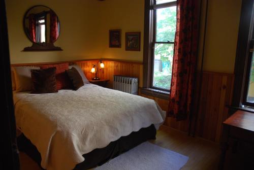 1 dormitorio con cama, ventana y espejo en Victoria Falls House en Nelson