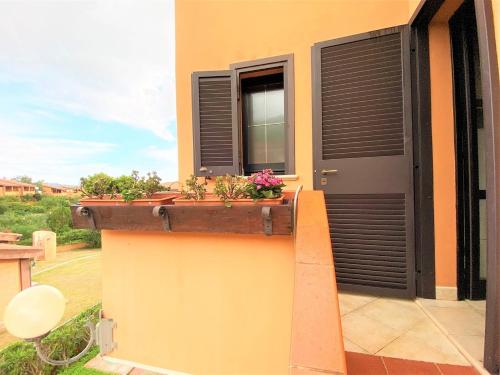 a house with a window with flowers in a planter at SU BISU Costa Rei R4991 terrace with sea view, 500m from the beach in Costa Rei